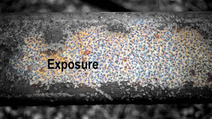 film still: *Exposure* title card: This image is of an orange/brown rust-covered steel beam. In Photoshop I removed the colour from the central zone of the image and overlaid the titles and credit text. (Also see credit cards below).

