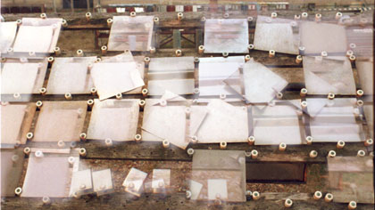 film still: Slippage: This tracking sequence was constructed at the site on my Nikon stills camera using a number of 36exp. 35mm rolls. These rolls of film were hand-processed at different temperatures, dilutions and timings – giving a varied mix of under/over exposure and high/low contrast &amp; saturation levels. The results were scanned, mixed and printed up for shooting on my rostrum.

