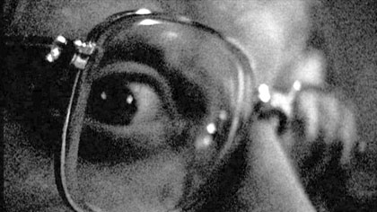 film still: Mr Budzik gives a furtive little glance as if to say “we know you’re out there”

